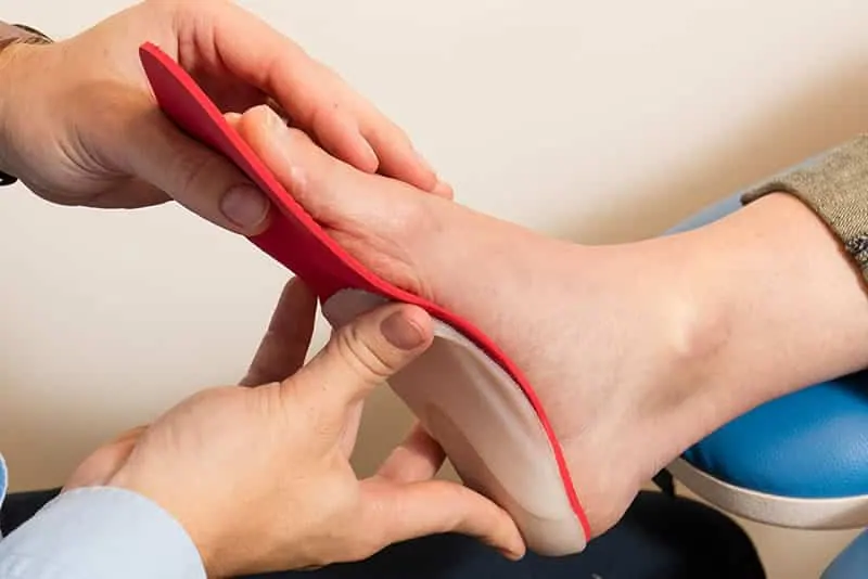 An orthotic insole being shaped to a patient's foot