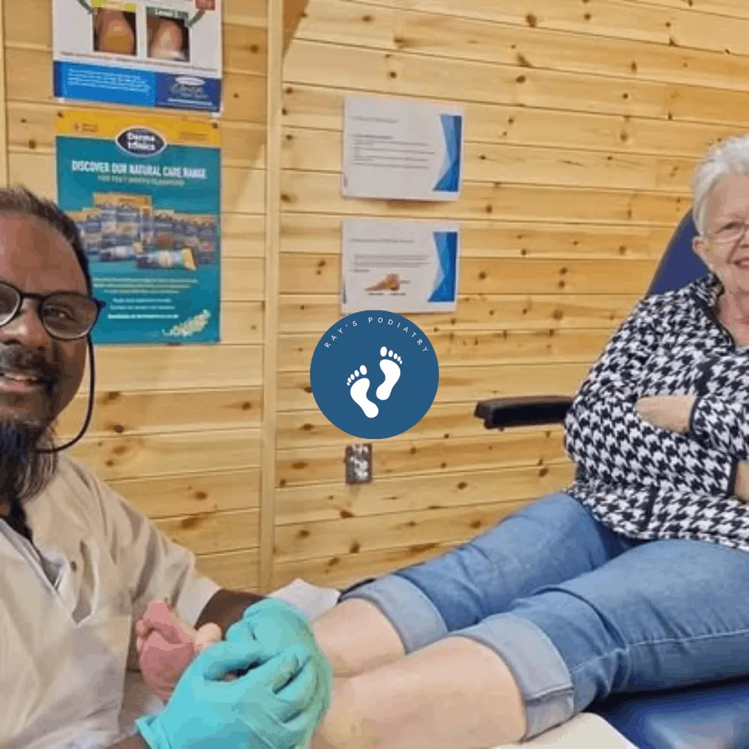 Ray smiling while treating a patient's foot