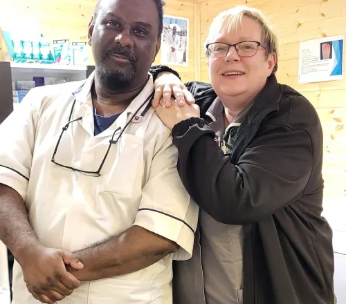 Ray standing with his arm around a patient in the treatment room